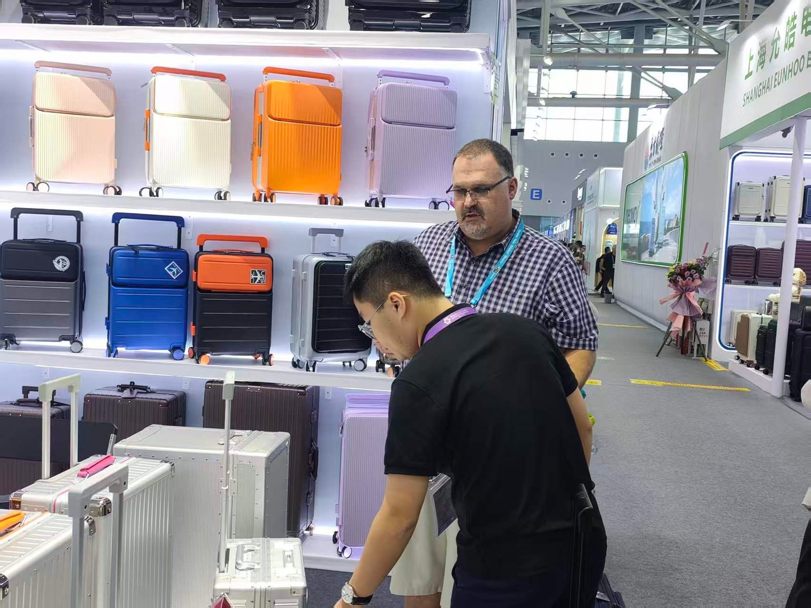 A buyer examining aluminium-frame cases on the shelf while a CLK staff member stands alongside