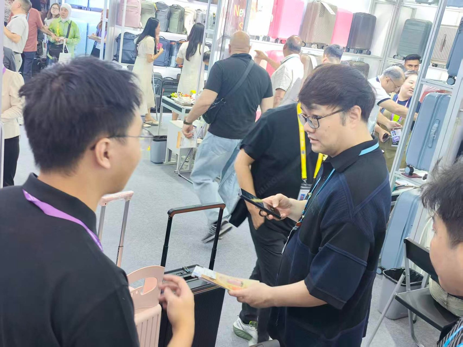 A CLK staff member showing a printed catalogue to a buyer beside a hard-shell case