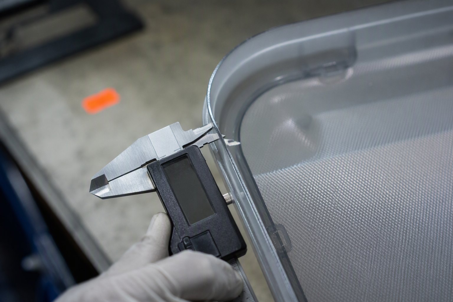 Digital caliper measuring the wall thickness of a polycarbonate luggage shell