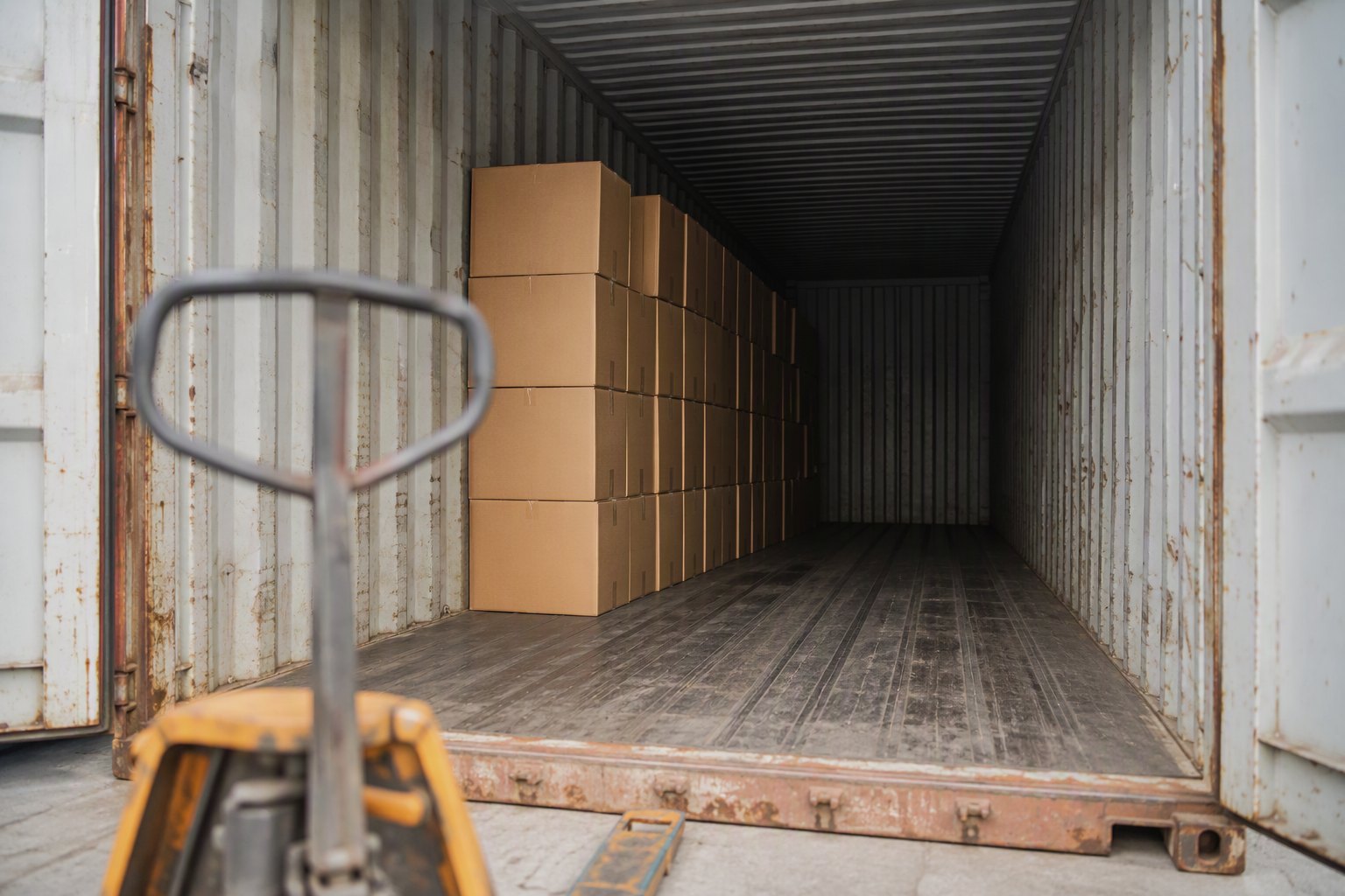 Partly loaded shipping container with plain corrugated cartons inside