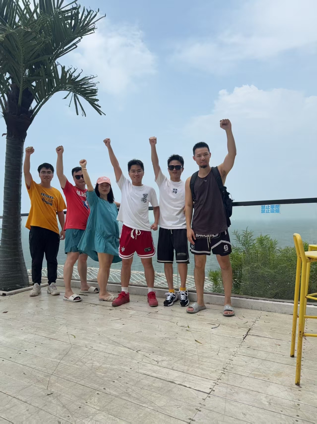 CLK Luggage team building 2026 - team with raised fists on sea-view terrace